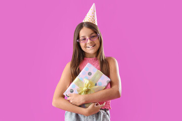 Happy little girl with Birthday gift box on purple background - obrazy, fototapety, plakaty