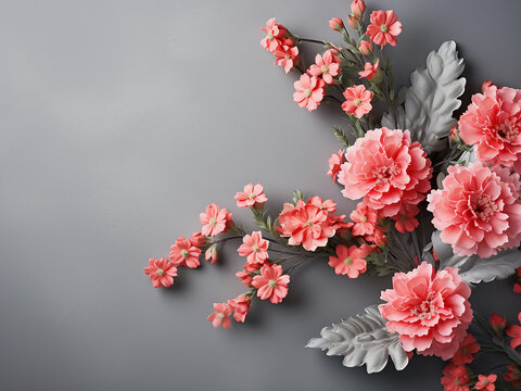 Coral carnations paired with silver-green senecio cineraria leaves on gray