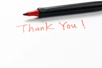 Schilderijen op glas Hand written thank you message with a red pen on white background, gratitude concept. © Kenishirotie