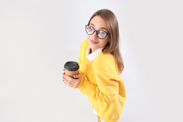 Young woman in eyeglasses with coffee cup on white background