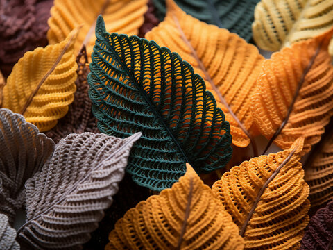 Leaves crafted from yarn, showcasing yellow, brown, and orange tones