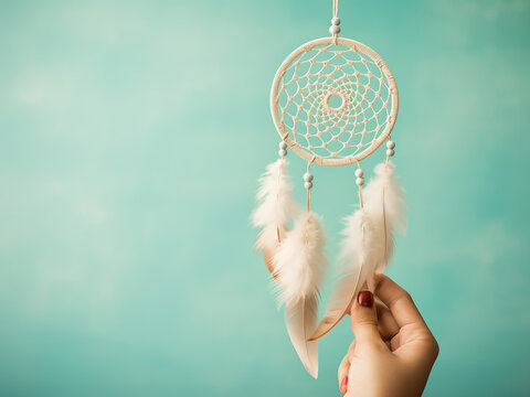 Mint cream dream catcher hangs against a turquoise backdrop textured like concrete
