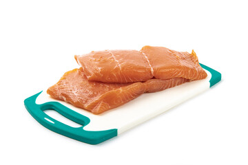 Pieces of Salmon filet on a white cutting board ready to be cooked isolated on white