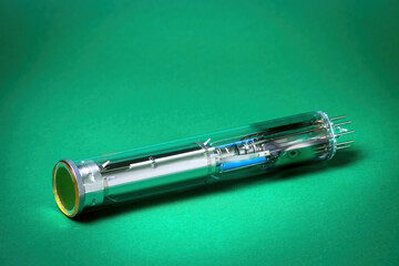 Vintage Camera Tube (Vidicon) on Green Background . Old Video Recording Technology