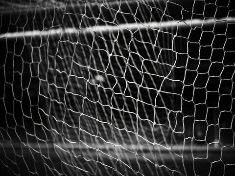 A soccer net stands out in the monochrome ambiance of a soccer stadium