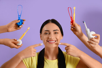 Beautiful young happy woman and hands holding supplies for oral hygiene on purple background