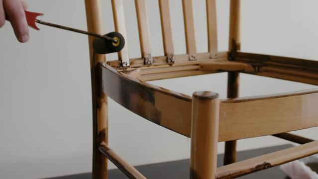 Restoration of a wooden chair. Covering with dark varnish. Close-up. Vintage things. High quality 4k footage