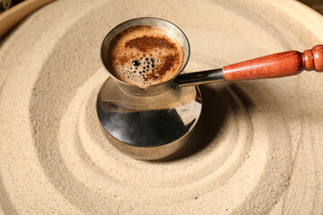 Coffee cooking in sand on wooden background