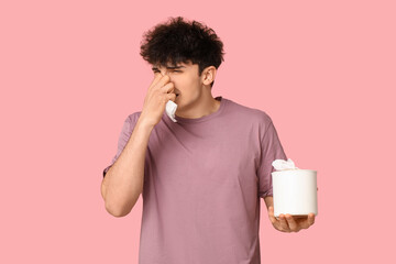 Young man with runny nose on pink background. Allergy concept - obrazy, fototapety, plakaty