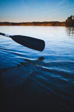 A paddle dips into calm waters during an evening paddle on Falls Lake, near Durham, North Carolina