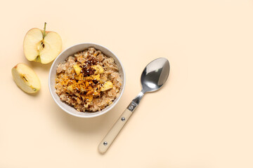 Tasty oatmeal with apple and cinnamon on beige background