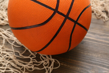 Ball for playing basketball and net on wooden background, closeup