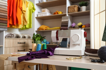Sewing machine on tailor's table in atelier