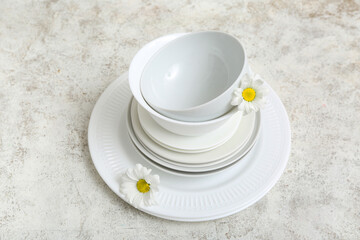 Tableware with beautiful chamomiles on grunge background