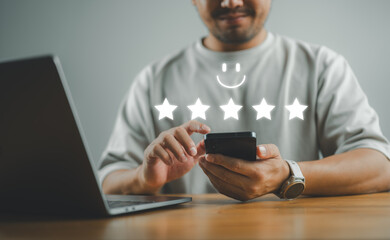 Man hand using smartphone with popup five-star icon for feedback review satisfaction service,...