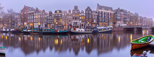 Panorama of Amsterdam canal Singel and dutch houses during morning blue hour, Holland, Netherlands.