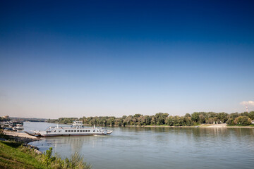 Panorama of the danube river in Mohacs, Hungary, with a ferro boat, Mohacsi komp, ready to cross the Danube from Mohacs to Ujmohacs, carrying cars and goods.