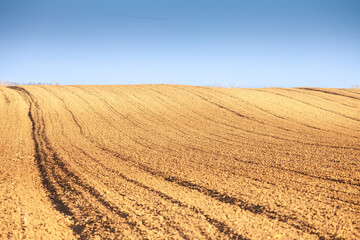 Selective blur on furrows on a Agricultural landscape, a plowed field in the countryside of deliblato, Serbia, in Voivodina. The plough is one of the techniques used in agriculture to fertilize a land