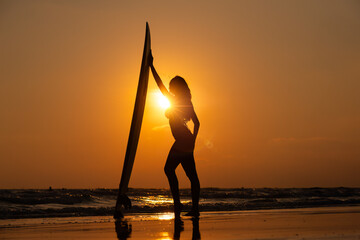 Silhouette sexy beautiful Asian model wearing bikini swimming suite posing happy on beach with...