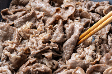 牛肉をフライパンで炒める調理シーン。
