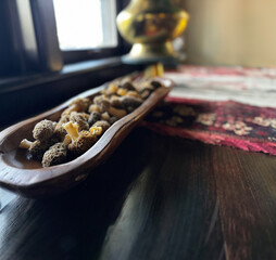 A real photograph of morel mushrooms in a live edge wooden platter - a tapestry and a wooden...