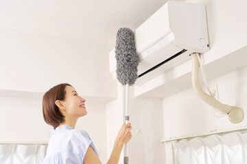 エアコンの掃除をする女性