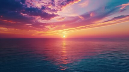 Aerial view of a vibrant sunset over the ocean, painting the sky with streaks of orange, purple, and pink
