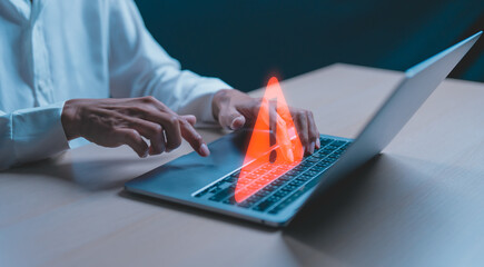 Businessman or programmer, developer using computer laptop with triangle caution warning sign for...
