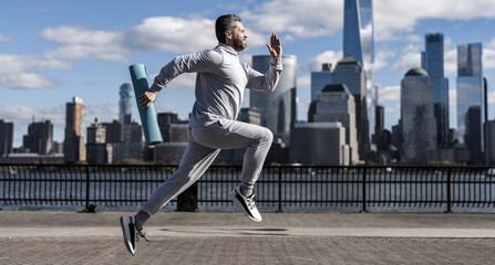 The sportsman running at view to New York. Man sportsman running for exercise in active wear....