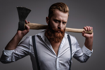 Handsome and charismatic. Masculine man. Masculinity of bearded man with axe isolated on grey....