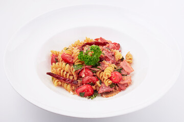 Stir-fried fusilli dried chili with ham and bacon served on white plate isolated on white background.