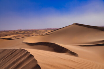 A sand dune of sahara desert at Mhamid el Ghizlane in Morocco telephoto shot - obrazy, fototapety, plakaty