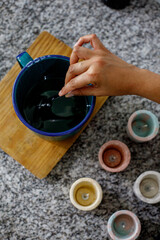 mano de muher haciendo velas de soya