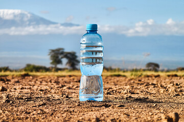 A bottle of water on dried ground. The concept of thirst, dehydration. problem of global warming...