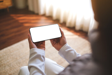 Mockup image of a woman holding mobile phone with blank desktop white screen at home - 780246713