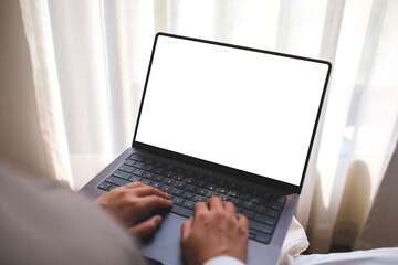 Mockup image of a woman working and typing on laptop computer with blank white desktop screen at home - 780246753