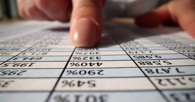 Accountant works with many numbers in table on piece of paper