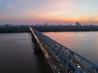 Obraz premium Aerial view of Chuong Duong bridge crossing Red River in Hanoi at sunset