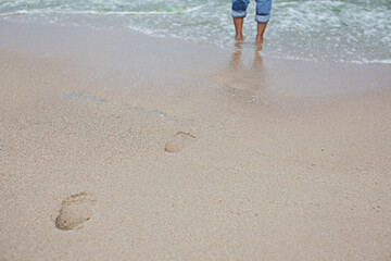 Footprints of people on the sand beach, sea, walking down to swim for relaxation or holidays.