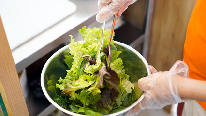 Person Holding Bowl of Salad With Gloves