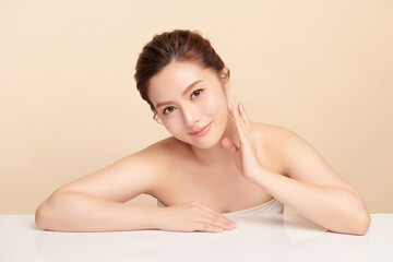 Fototapeta premium Beautiful young asian woman with clean fresh skin on beige background, Face care, Facial treatment, Cosmetology, beauty and spa, Asian women portrait.