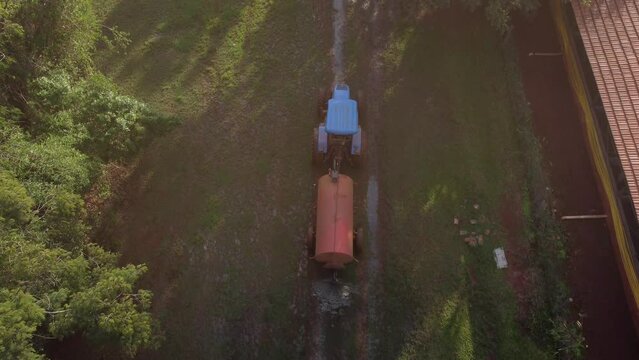 Tractor with fertilizer spreader preparing for planting on land in the interior of Brazil. Raw Footage.
