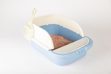 Isolated on a white background a plastic cat litter toilet tray with scoop is a hygiene and care...