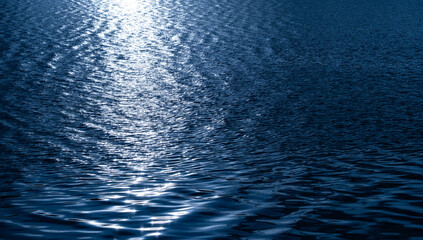 Deep sea waves, blue surface, of ocean navigation. There are ripples and bubbles. The sunlight shines brightly.	