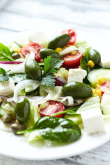 Healthy Salad with Feta Cheese, Green Olives, Baby Spinach, Cucumber, Cherry Tomatoes and Capers. Bright background. Close up.	