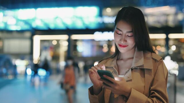Charming Woman Stands in the Middle of Street and Scrolls Through Her Phone, Scrolling Through Photos, Watching News. Positive Adorable Girl Browsing on the Internet Outside. People and Technology