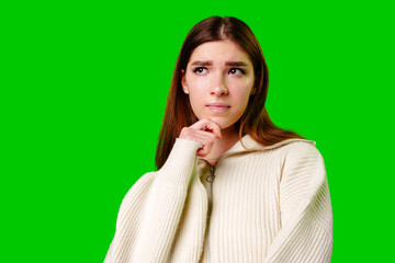 Young Woman Deep in Thought Against a Green Screen Background