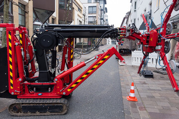 Small red tractor with suction cups to replace shop windows on a narrow city street.