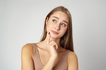 Fototapeta premium Thoughtful Young Woman Posing iAgainst a Plain Background