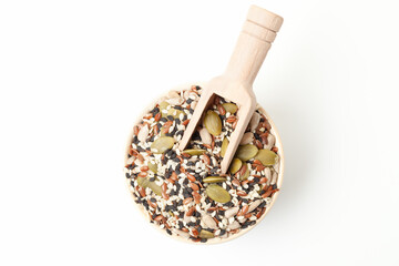 Mixed seeds sunflower, black and white sesame, flax and pumpkin in bowl with wooden scoop on white background. Top view
